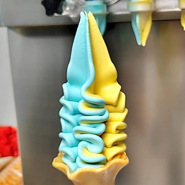 Glace italienne aux saveurs mixées, bleu et jaune, servie par la machine à glace professionnelle.